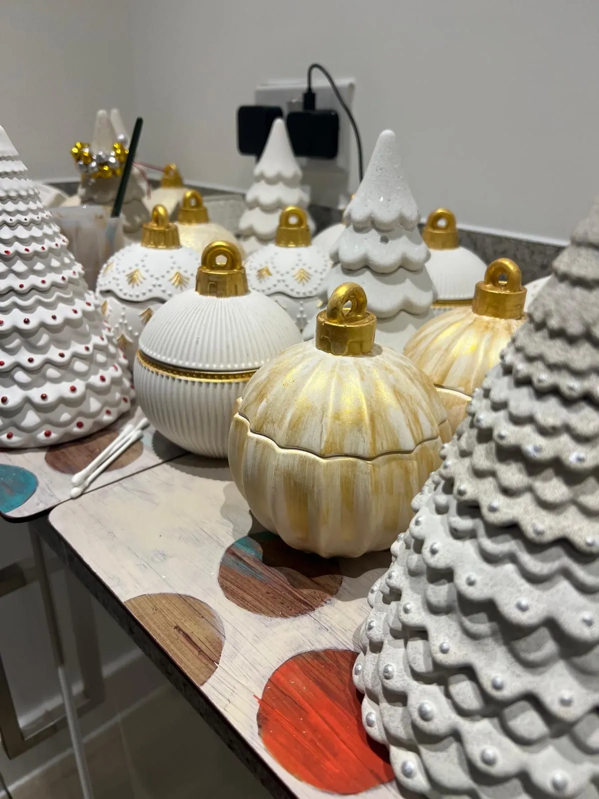 Holiday ornaments and sculpted tree candles in the workshop